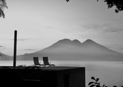 Black and white view of the rooftop of Room Two at Anzan Atitlán with two chairs, overlooking Lake Atitlán in the morning mist.