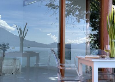 Room One at Anzan Atitlán with minimalistic design and floor-to-ceiling windows offering clear views of Lake Atitlán and lush surroundings.