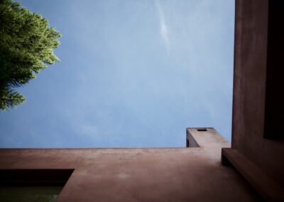 Minimalist pink facade of "Anzan Atitlán = Casa Rosada" architecture, a landmark on Lake Atitlán's shore under a clear blue sky.