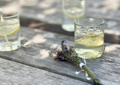 Cocktail hour at Anzan Table: bespoke drinks infused with local herbs, served on the dock or stone beach at Lake Atitlán, with guests sipping barefoot by the water before a farm-to-table dinner.